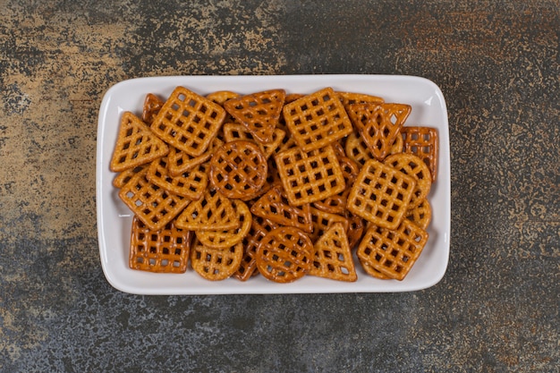 Foto grátis vários biscoitos salgados na chapa branca.