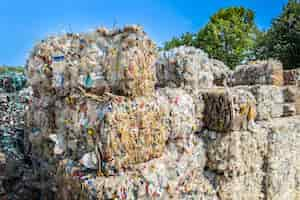 Foto grátis vários cubos de lixo plástico compactado perto da fábrica de reciclagem de resíduos ao ar livre