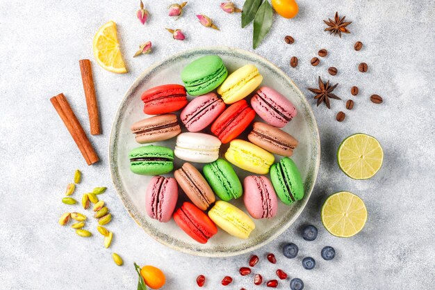 Vários macaroons com pistache, frutas, bagas, grãos de café.