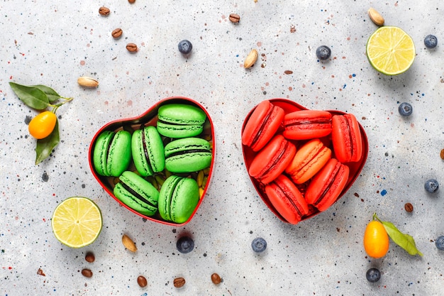 Vários macaroons com pistache, frutas, bagas, grãos de café.