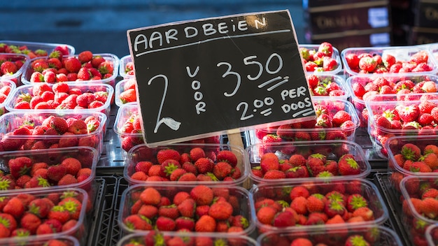 Foto grátis vários morangos com preço de exibição de um mercado local de agricultores