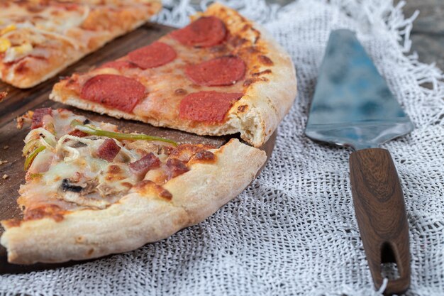 Vários tipos de fatias de pizza na placa de madeira.