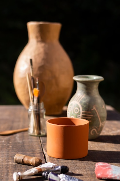 Vaso de cerâmica de vista frontal e ferramentas de pintura