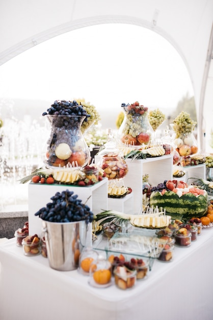 Vaso de vidro com suporte de uva na mesa de jantar com frutas