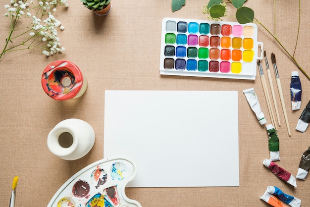 Foto grátis vaso e tintas perto da folha de papel