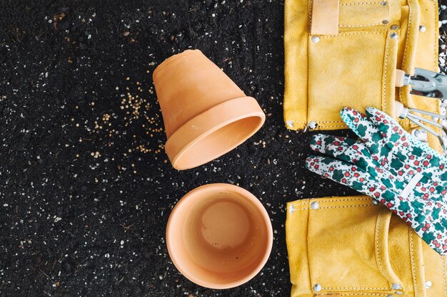 Vasos vazios perto de saco com ferramentas de jardinagem