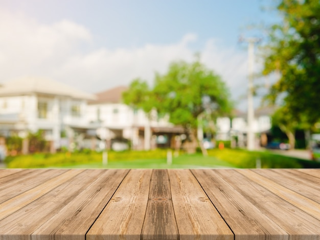 Vazio topo de mesa de madeira no borrão resumo verde do jardim e da casa na manhã background.For montagem produto exibição ou design layout visual chave
