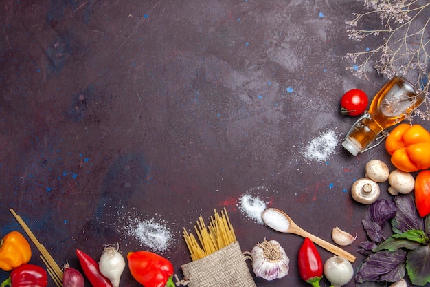 Vegetais frescos com massa crua na superfície escura salada de comida saudável