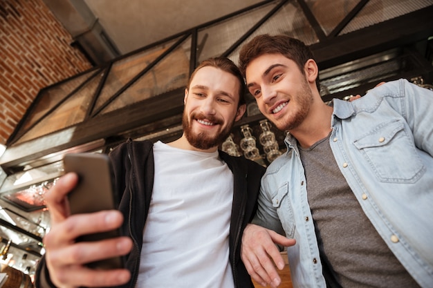 Foto grátis veja abaixo amigos usando o telefone