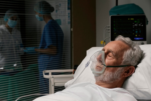 Foto grátis velho com respirador em uma cama de hospital