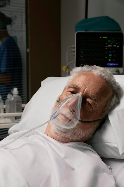 Foto grátis velho com respirador em uma cama de hospital