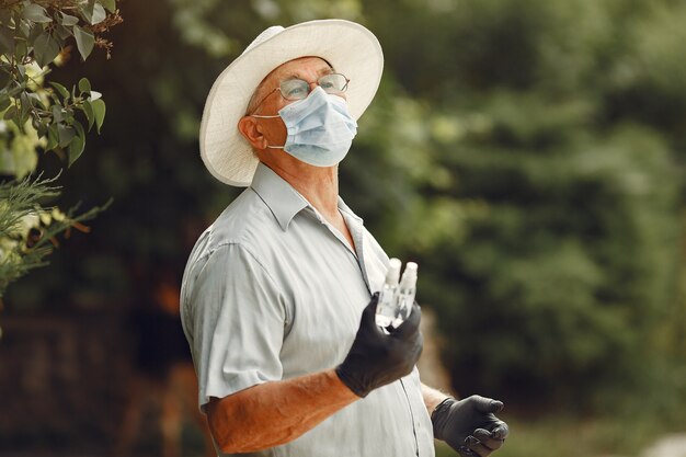 Velho com uma máscara médica. Homem no parque. Tema Coronavirus.