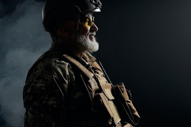 Velho oficial militar em pé na escuridão