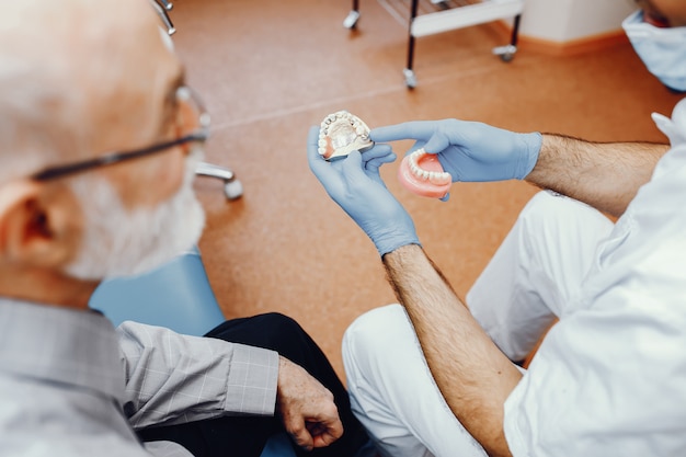 Velho sentado no consultório do dentista