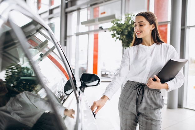 Vendedor feminino em uma sala de exposições de carros