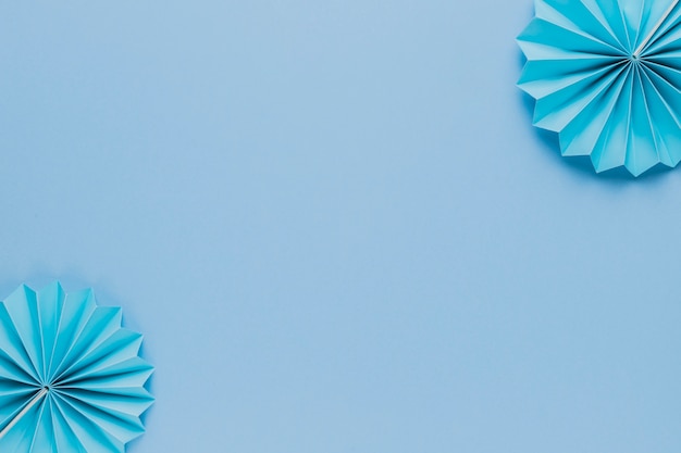 Foto grátis ventilador de papel origami azul no canto do pano de fundo azul