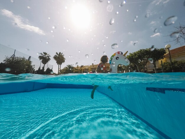 Verão e piscina conceito com mulher no unicórnio inflável