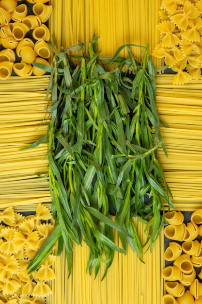 Verdes de estragão de vista superior com macarrão e espaguete na forma de uma decoração