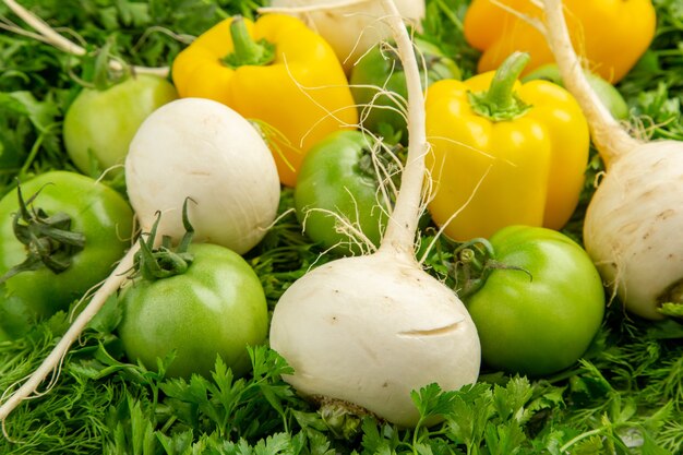 Verdes verdes frescos com tomates verdes, rabanete e pimentões no fundo branco refeição dieta saudável vida cor de salada foto