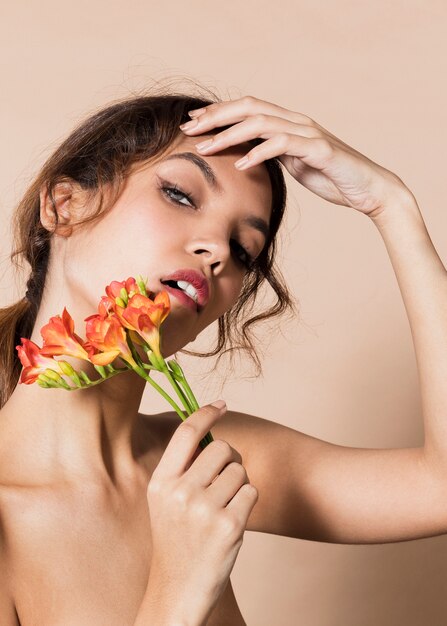 Veritcal tiro mulher segurando flores laranja