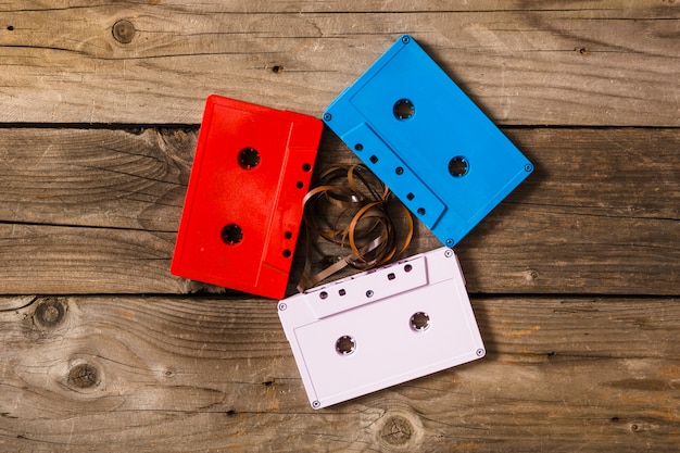Foto grátis vermelho; fitas cassete brancas e azuis com fita emaranhada em fundo de madeira