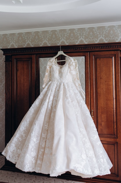 Vestido de noiva pendurado em um guarda-roupa