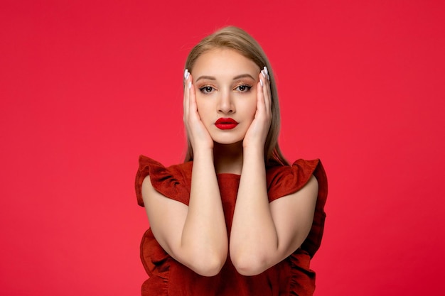 Vestido vermelho linda garota adorável de vestido cor de vinho com batom vermelho tocando o rosto de ambos os lados