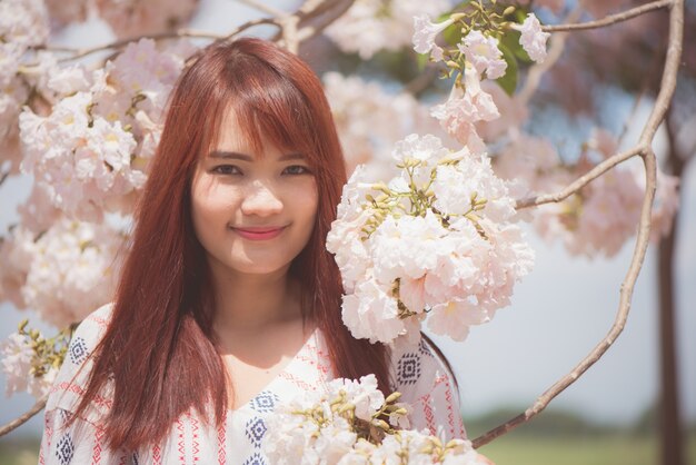 Viajante de mulher feliz, relaxe, sinta-se livre com flores de cerejeira ou árvore de flor de sakura em férias