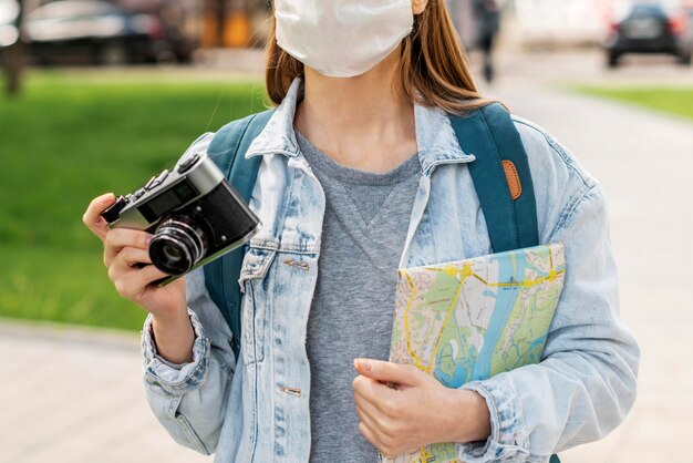Viajante, desgastar, máscara médica, segurando, mapa câmera