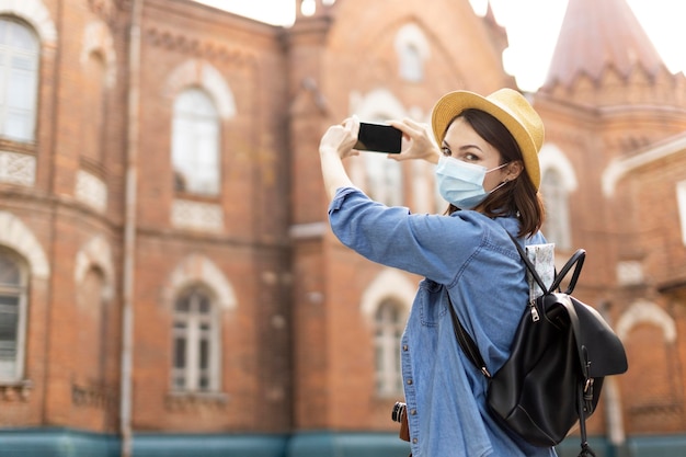 Viajante elegante com chapéu tirando fotos de férias