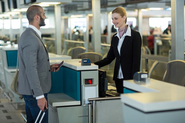 Viajante sorridente interagindo com o atendente no balcão de check-in