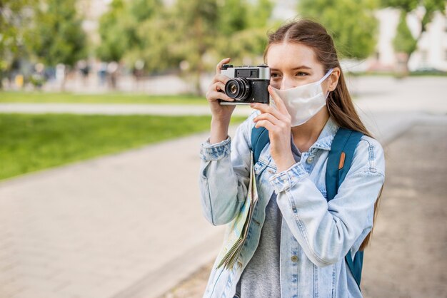 Viajante usando máscara médica tirando uma foto