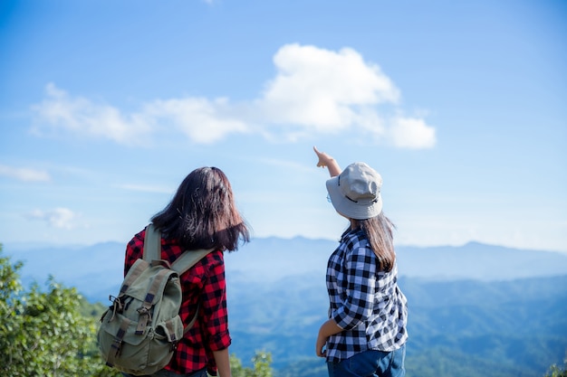 Viajantes, mulheres jovens, olhem para as incríveis montanhas e florestas, ideias de viagens por viagens,