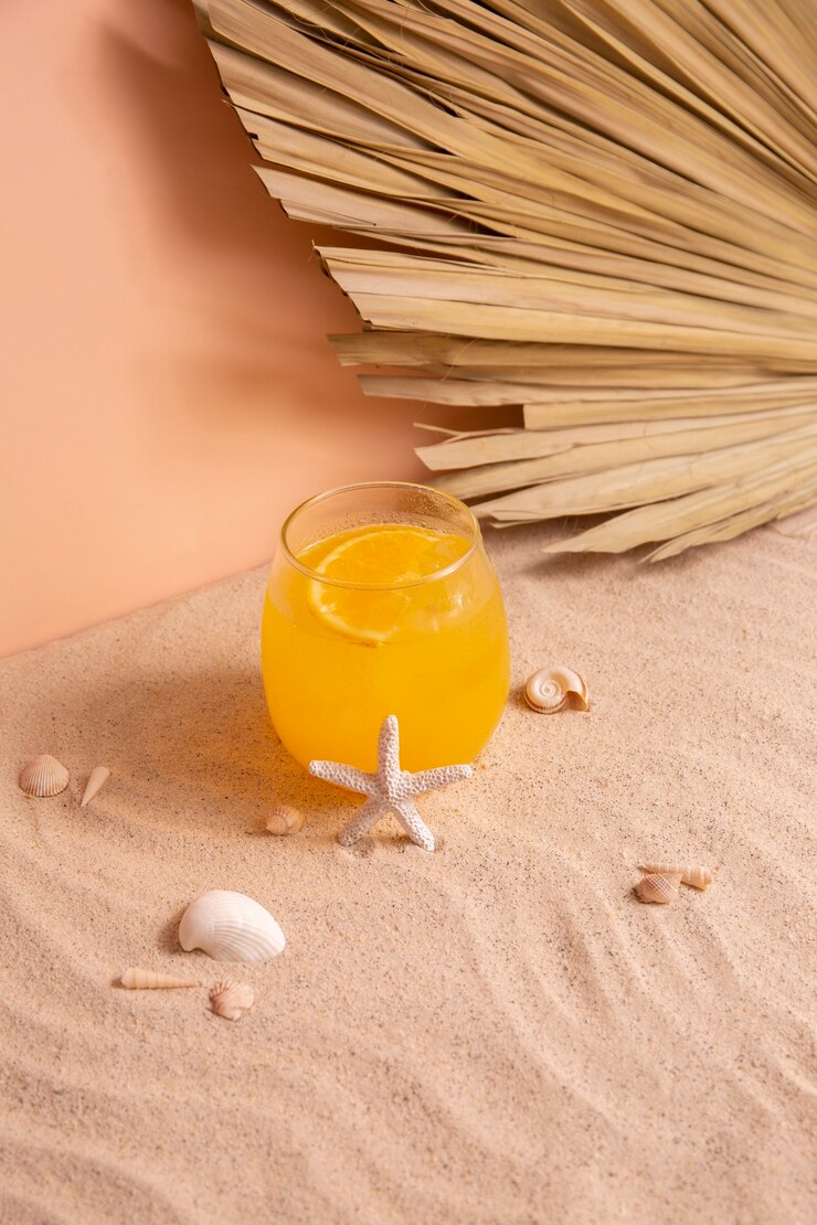 Foto grátis vibrações de verão com areia e coquetel de laranja