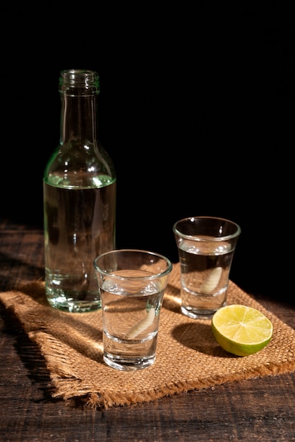 Foto grátis vida morta de bebida de mezcal com verme maguey