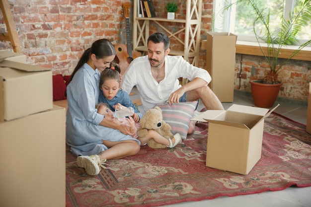 Vida nova. Família adulta mudou-se para uma nova casa ou apartamento. Cônjuges e filhos parecem felizes e confiantes