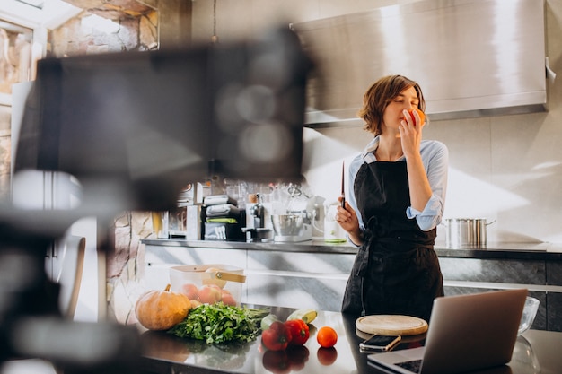 Videoblogger jovem cozinhar na cozinha e filmar