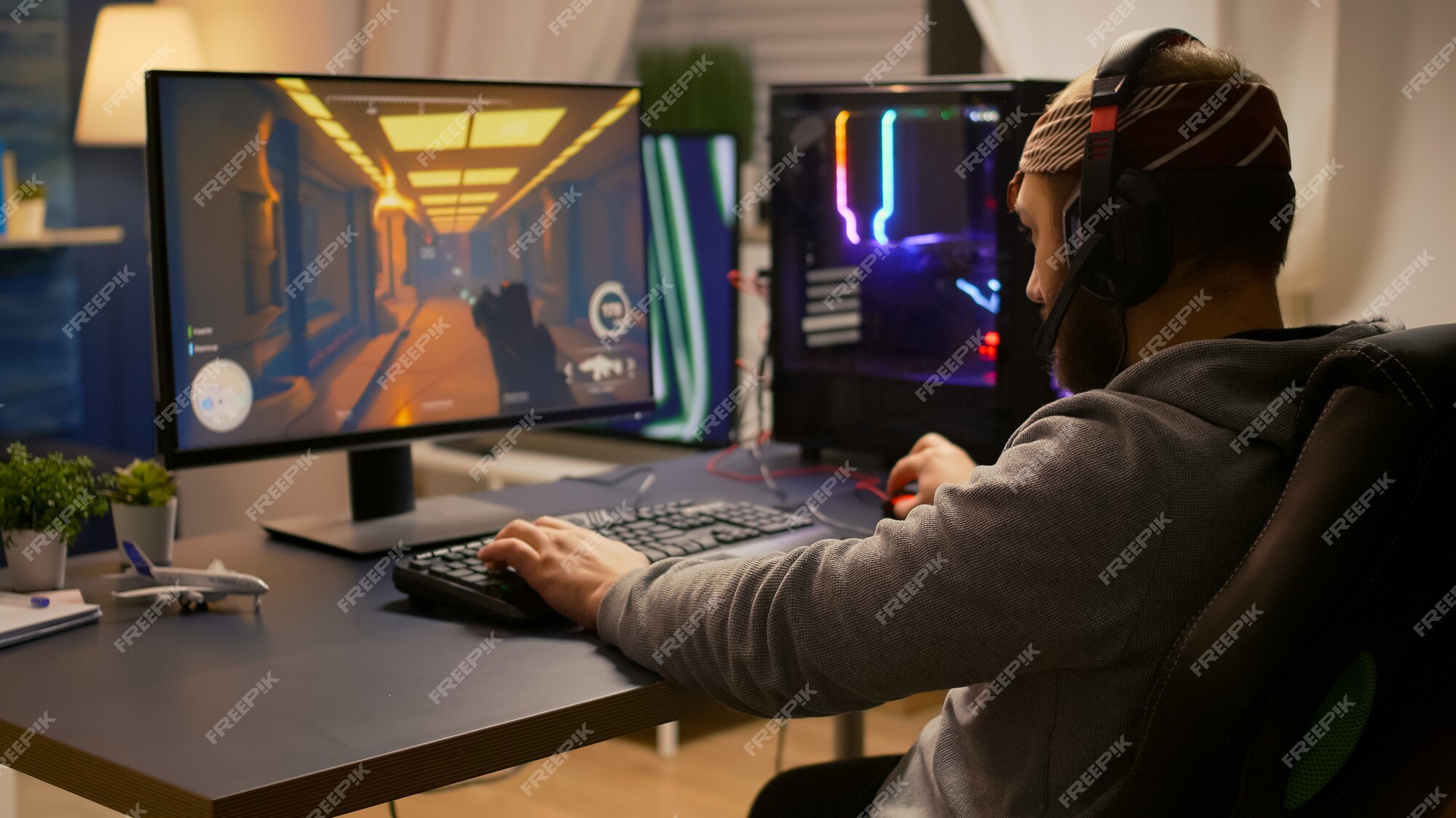 Homem usando configuração de jogos de pc relaxante jogando jogo de ação online  multiplayer conversando com a equipe no fone de ouvido no torneio. gamer  transmitindo o jogo de tiro em primeira