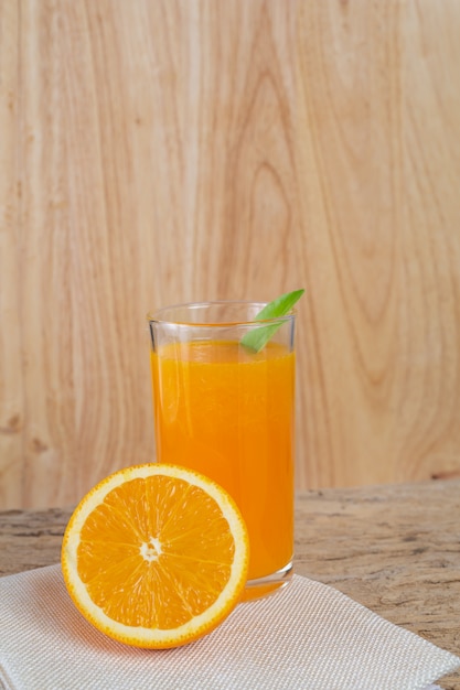 Foto grátis vidro do sumo de laranja colocado na madeira.