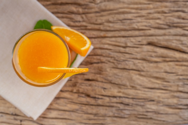 Vidro do sumo de laranja colocado na madeira.