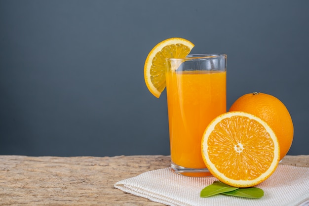 Vidro do sumo de laranja colocado na madeira.