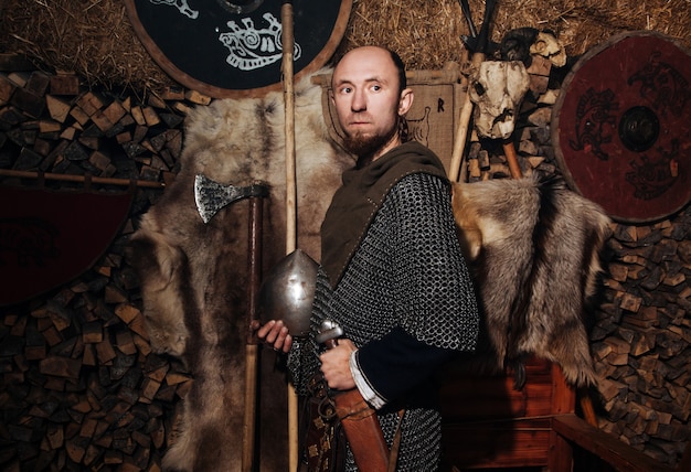 Viking posando contra o antigo interior dos vikings.