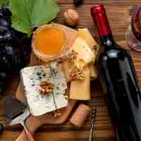 Foto grátis vinho com comida no fundo de madeira