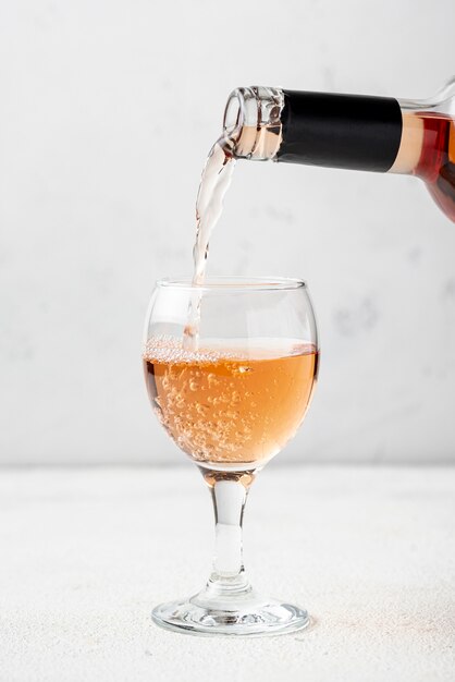 Vinho rosé derramado em copo para degustação