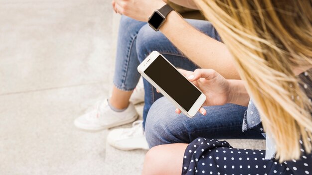 Visão aérea da mulher olhando para a tela do celular