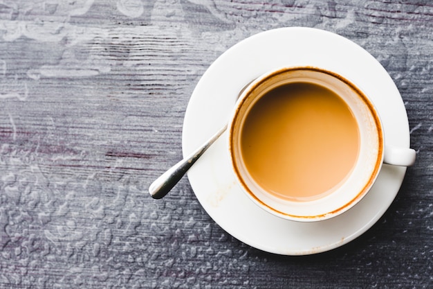 Visão aérea da xícara de café no pano de fundo de madeira molhada