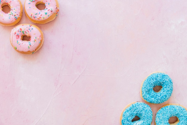 Visão aérea de deliciosos donuts no pano de fundo rosa