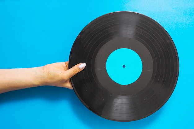 Foto grátis visão aérea, de, femininas, mãos, segurando, registro vinil, ligado, experiência azul