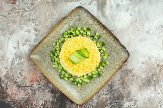 Visão aérea de uma saborosa salada servida com pepino picado em um fundo de cor mista