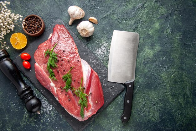 Visão aérea de verde em carne crua vermelha fresca em uma tábua de cortar e pimenta limão preto flor martelo em fundo de cor verde preto mix